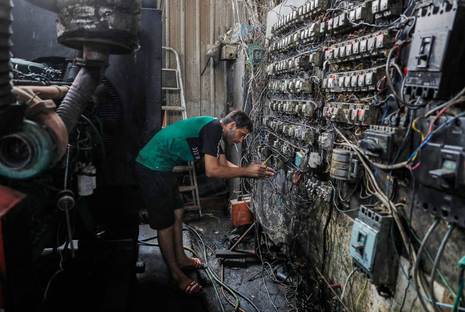 A technician controls an electric switch board connecting homes to privately-owned electricity generators in a suburb of Iraq's capital Baghdad on June 30, 2021 as the national electric grid is experiencing outages amidst a severe heat wave.<span class="copyright">Ahmad Al-Rubaye—Getty Images/AFP</span>