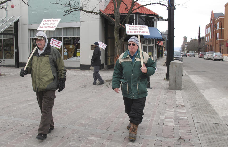 Striking bus drivers Rick LaFerriere, left, and Derek Lorrain walk a picket line Wednesday March 26, 2014 in Burlington, Vt. The strike continued into a second week, leaving thousands of people scrambling to find ways to get to work, school and appointments. (AP Photo/Wilson Ring)