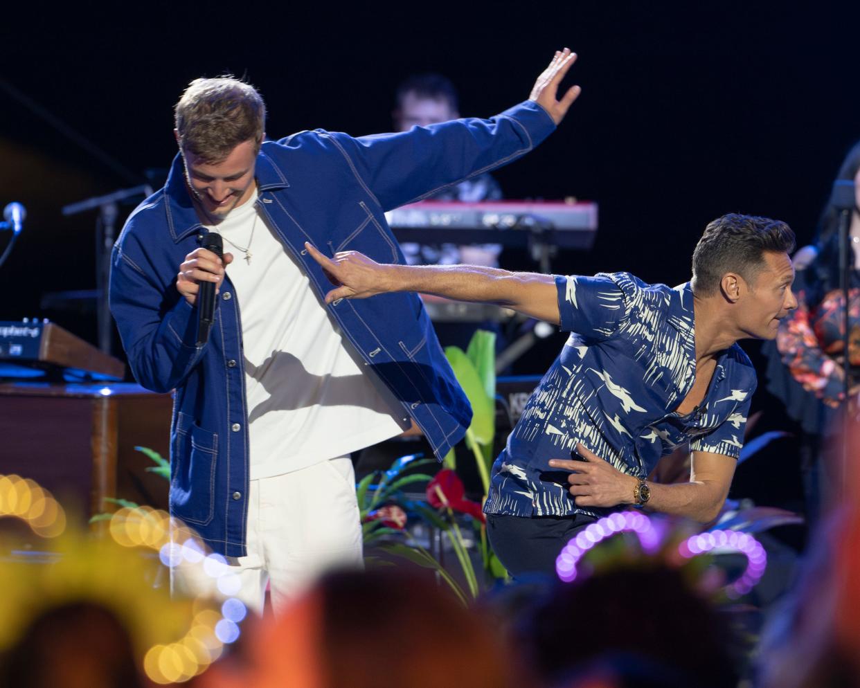 Ryan Seacrest (right) mimics Blake Proehl's football-inspired dance move as the top 24 contestants perform on Season 22, Episode 8, of "American Idol," airing April 7, 2024.