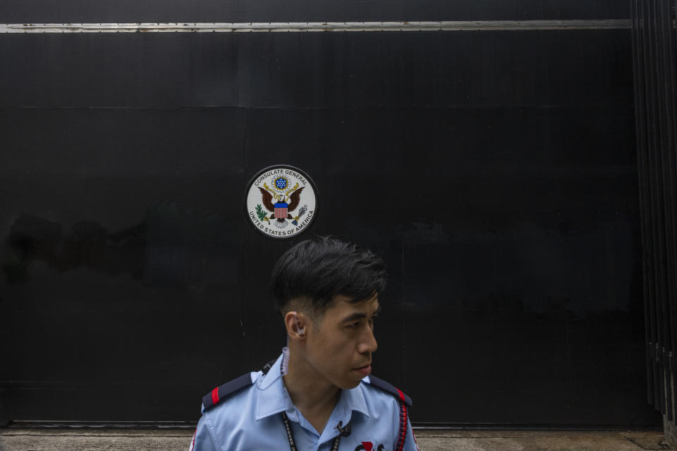 Security guards stand outside the Consulate General of the United States after it was vandalized with graffiti in Hong Kong, Tuesday, June 13, 2023. Hong Kong police on Tuesday arrested a man who allegedly spray-painted graffiti on the wall and gate of the U.S. consulate, according to media reports and the police. (AP Photo/Louise Delmotte)