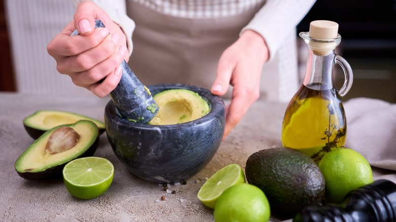 Person making gucamole in a molcajete