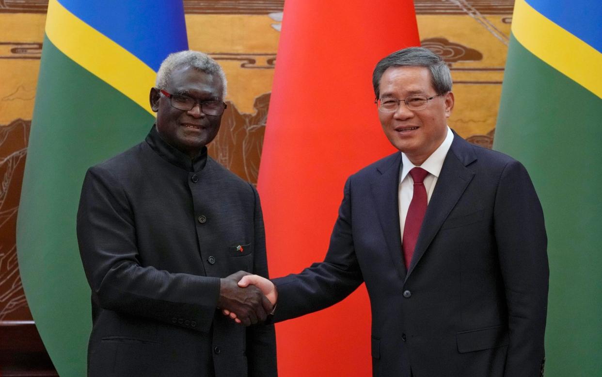 Manasseh Sogavare, left, signed a security pact with Li Qiang, his Chinese counterpart, right