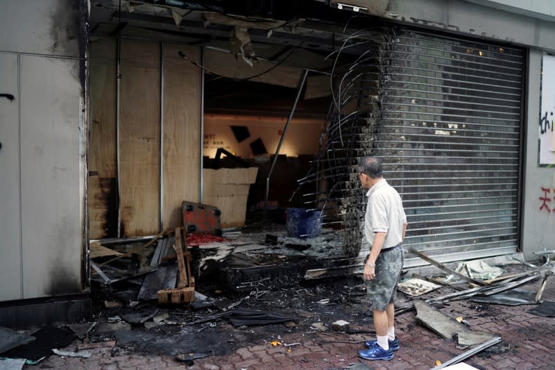 A man inspects a shop which was vandalised during Sunday's anti-government protest in Hong Kong