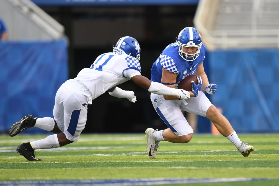 DB Moses Douglass tackles TE Justin Rigg during the University of Kentucky Spring blue-white football game at Kroger Field in Lexington, Kentucky on Friday, April 12, 2019. 