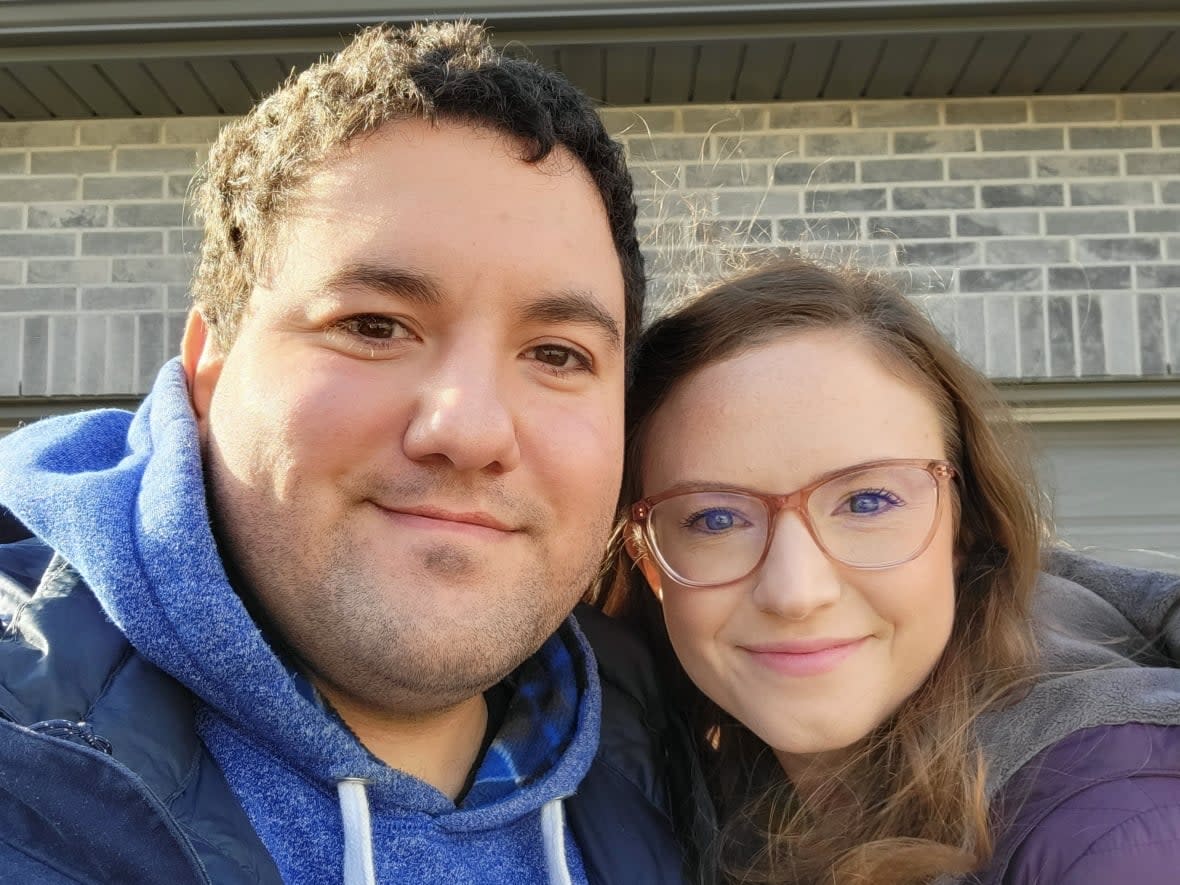 Lucas Berthault and Erin Gardner are shown in front of what they hope will be their first home in Tillsonburg, Ont. The couple's sales agreement for the pre-construction townhouse was cancelled in June, with the developer asking for more money. But the case is likely to go to arbitration. (Submitted by Lucas Berthault - image credit)