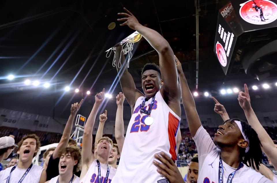 Oklahoma Christian School's Luke Gray (25) celebrates with the Class 3A boys basketball state championship trophy after beating Millwood on Saturday at State Fair Arena.