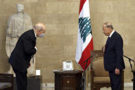 In this photo released by Lebanon's official government photographer Dalati Nohra, French Foreign Minister Jean-Yves Le Drian, left, and Lebanese President Michel Aoun, greet each other at the Presidential Palace in Baabda, east of Beirut, Lebanon, Thursday, May 6, 2021. Le Drian began a visit to Lebanon Thursday with a message of "great firmness" to its political leaders, threatening to take additional measures against officials obstructing the formation of a government in the crisis-hit country. (Dalati Nohra via AP)