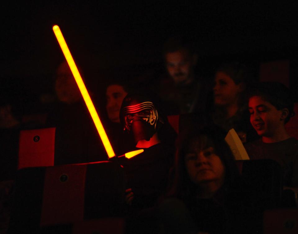 Reece Vanderslice 9, of Newark holds his broad sword lightsaber in his movie seat waiting for Star Wars: The Force Awakens to begin at the Westown Movies in Middletown on December 17, 2015.