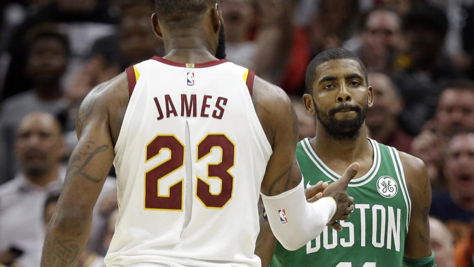 Kyrie Irving and LeBron James share a moment after their first meeting since parting ways. (AP)