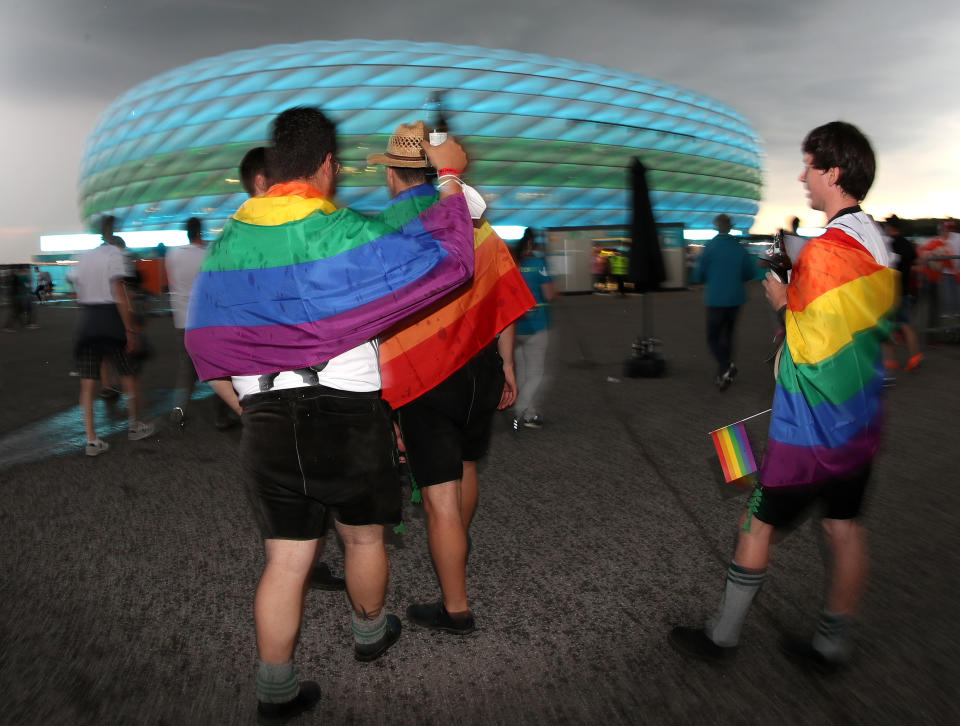 UNSPECIFIED, GERMANY - JUNE 23: Fans of Germany covered with rainbow flags toast with beer in front of the Allianz Arena soccer stadium illuminated in green and blue ahead of the Euro 2020 Group F match between Germany and Hungary on June 23, 2021 in Munich, Germany during EURO 2020.  (Photo by Alexandra Beier/Getty Images)