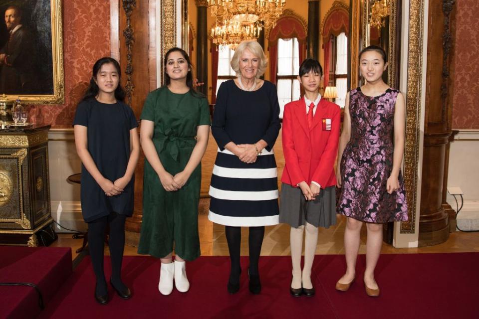 <p>Camilla Parker Bowles wore a striped navy and white dress and pearl necklace for a reception at Buckingham Palace for winners of the Queen's Commonwealth Essay Competition. </p>