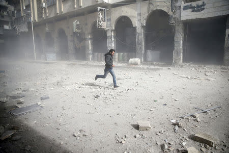 A man is seen running after an air raid in the besieged town of Douma in eastern Ghouta in Damascus, Syria, February 6, 2018. REUTERS/ Bassam Khabieh