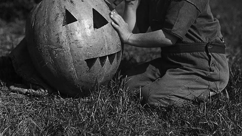 vintage photograph of boy carving jack o lantern