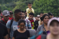 Migrants, many from Central American and Venezuela, walk along the Huehuetan highway in Chiapas state, Mexico, early Tuesday, June 7, 2022. The group left Tapachula on Monday, tired of waiting to normalize their status in a region with little work and still far from their ultimate goal of reaching the United States. (AP Photo/Marco Ugarte)