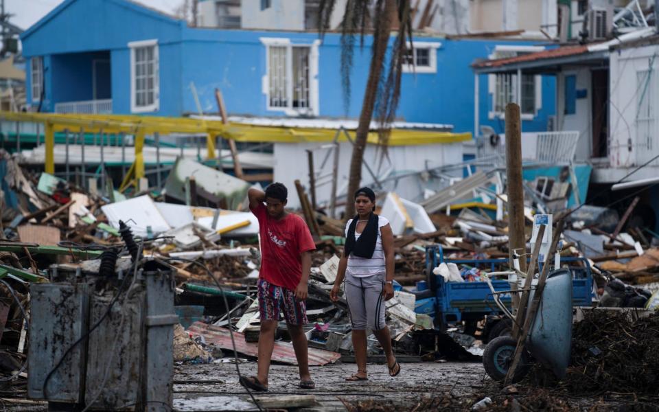 People walk near damaged houses and fallen electricity poles after the passage of Storm Iota, in Providencia  - Nathalia Angarita/REUTERS