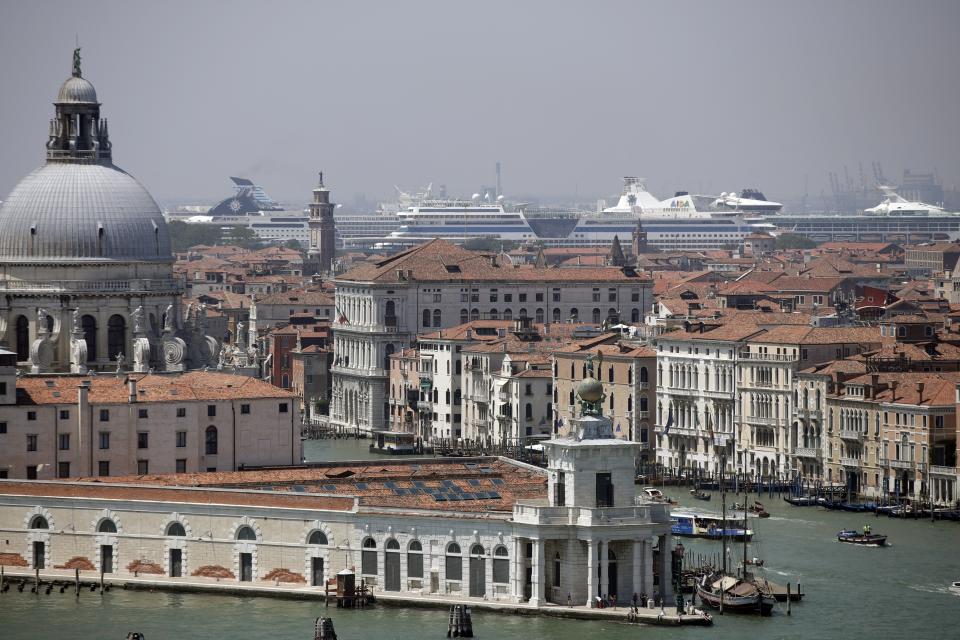 FILE-- Cruise ships are moored at Venice's harbor in Venice, Italy, Saturday, June 8, 2019. Declaring Venice's waterways a “national monument,” Italy is banning mammoth cruise liners from sailing into the lagoon city, which risked within days being declared an imperiled world heritage site by the United Nations. Culture Minister Dario Franceschini said the ban will take effect on Aug. 1 and was urgently adopted at a Cabinet meeting on Tuesday. (AP Photo/Luca Bruno)