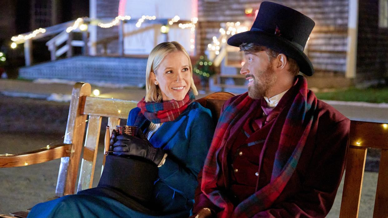  Jessy Schram ad Chandler Massey sit on a bench in Mystic Christmas. 