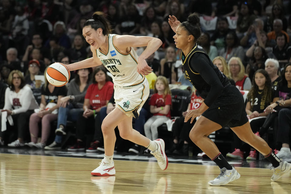 New York Liberty forward Breanna Stewart (30) drives against Las Vegas Aces forward Alysha Clark (7) during the first half in Game 1 of a WNBA basketball final playoff series Sunday, Oct. 8, 2023, in Las Vegas. (AP Photo/John Locher)