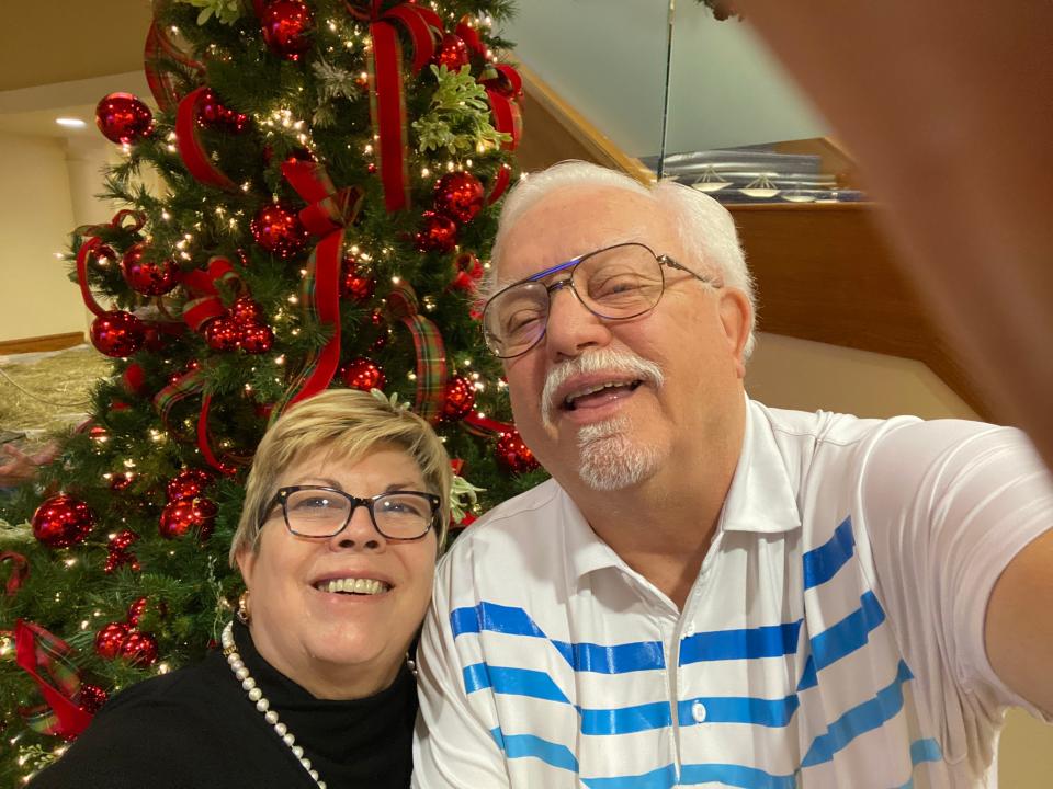 Senior newlyweds Judy and Evans Wagner take a selfie aboard a cruise in front of a Christmas tree.