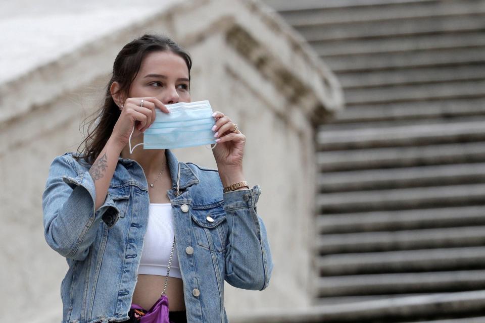 A woman puts on a face mask in Rome on 6 October, 2020.  (AP)