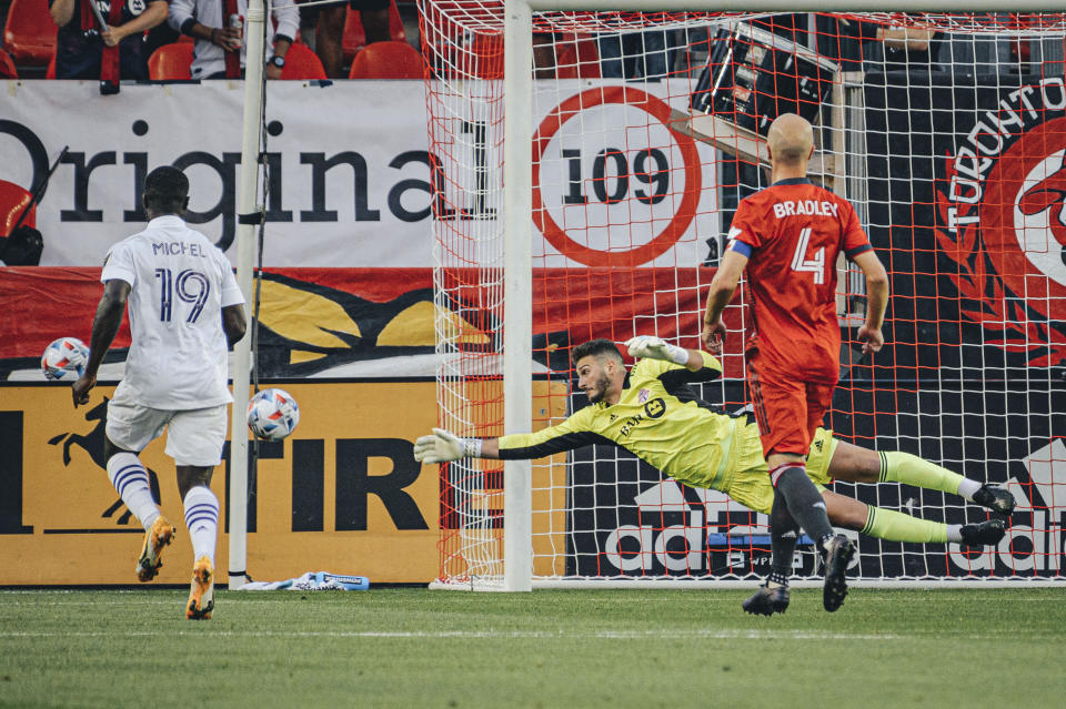 Toronto FC goalkeeper Alex Bono, center, defends the net as Orlando City SC's Benji Michel (19) looks on during first-half MLS soccer match action in Toronto, Saturday, July 17, 2021. (Chris Katsarov/The Canadian Press via AP)