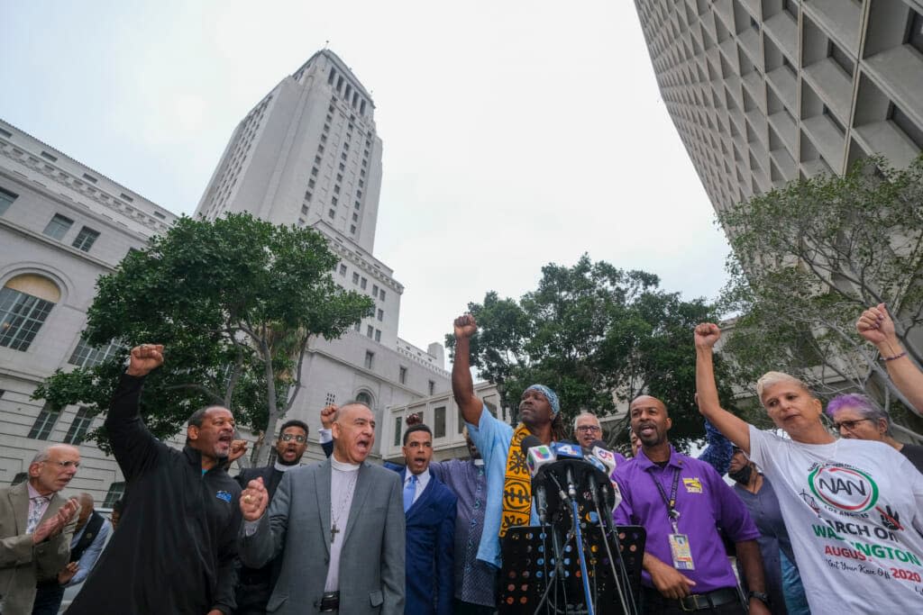 Faith, labor, immigrant and community members attend in a news conference to denounce racism and demand change in response to a recorded, racially charged leaked conversation between leaders at City Hall and the Los Angeles County Federation of Labor President, before the Los Angeles City Council meeting outside city hall Tuesday Oct. 11, 2022 in Los Angeles. (AP Photo/Ringo H.W. Chiu)