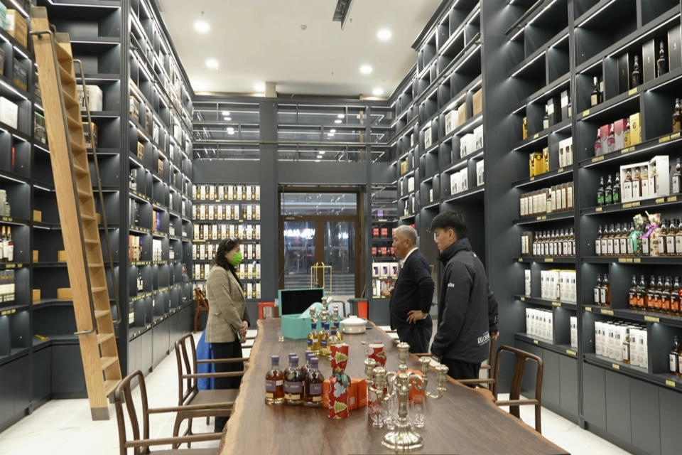 In this image from a video, Raymond Lee, founder of Single Malt Club China, second from right, visits a whisky store in Beijing on Dec. 9, 2023. The more than $100 million distillery owned by Pernod Ricard and based at the UNESCO World Heritage site Mount Emei, launched a pure-malt whisky, The Chuan, aiming to tap a growing taste among young Chinese for whisky in place of the traditional "baijiu" used to toast festive occasions. (AP Photo/Caroline Chen)