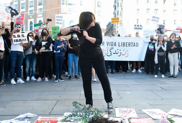 Una chica se corta el pelo, como forma de protesta, para pedir respeto por los derechos de las mujeres iraníes, en la plaza del Callao, a 1 de octubre de 2022, en Madrid (España).