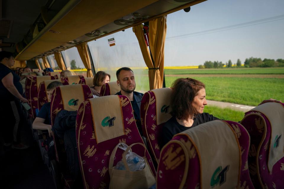 Ukrainian neurosurgeon Eduard Polianin, center, rests his eyes as he sits behind Irena Haleta, 37, from Kryvyi Rih, as Ukrainian children, their families and doctors depart Leczna, Poland, on Saturday, May 20, 2023 for their homes in Ukraine after receiving surgeries from Doctors Collaborating to Help Children.