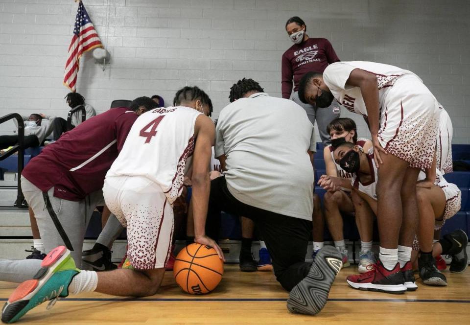 Players huddle around Warren County assistant coach Bryan Fuller, center and head coach Toriano McRae Jr., left, during the closing minutes of play against Bunn on Tuesday, February, 2, 2021 in Warrenton, N.C.