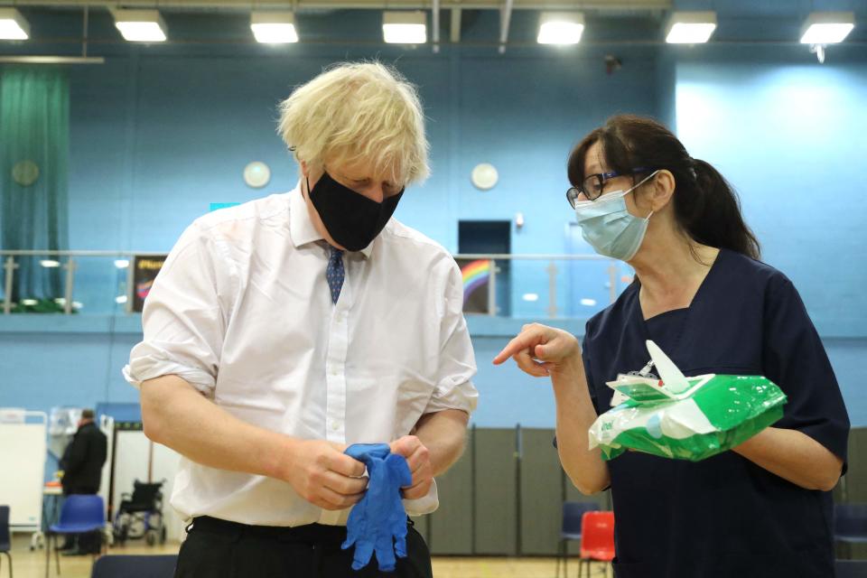 <p>The PM speaks with health worker Wendy Warren as he visits a vaccination centre in Cwmbran, south Wales </p> (AFP via Getty Images)