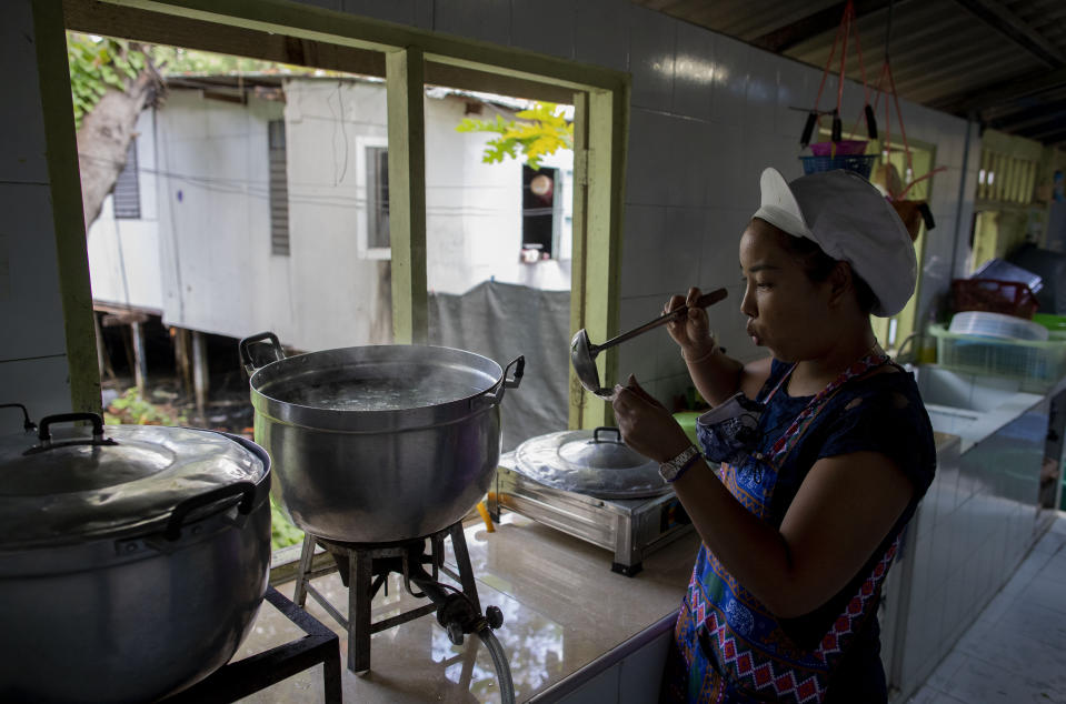 Katsane Sattapitak tastes a meal she is cooking for school children at Makkasan preschool kitchen in Bangkok, Thailand, Wednesday, June 24, 2020. During the third month that schools remained closed due to the coronavirus outbreak, teachers have cooked meals, assembled food parcels and distributed them to families in this community sandwiched between an old railway line and a khlong, one of Bangkok’s urban canals. (AP Photo/Gemunu Amarasinghe)
