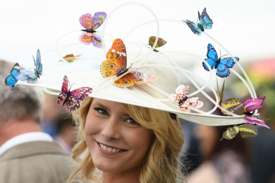 A racegoer wears a hat covered with butterflies on Day 1.