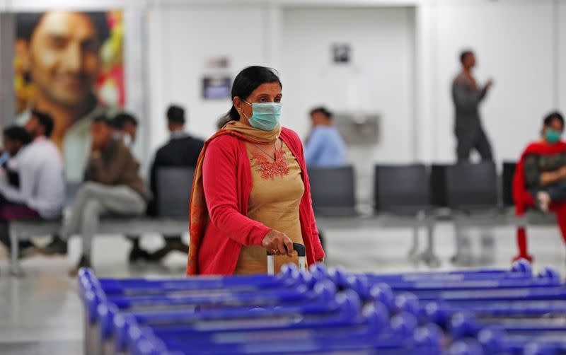 A passenger wearing a protective mask walks inside an airport terminal following an outbreak of the coronavirus disease (COVID-19), in New Delhi