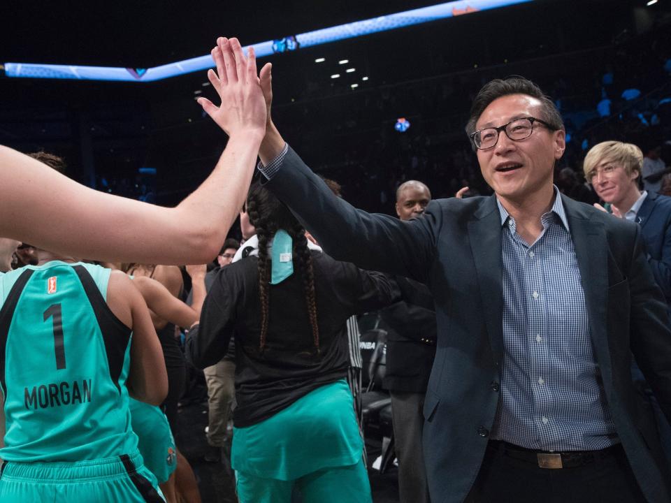 Team owner Joe Tsai high fives New York Liberty players.