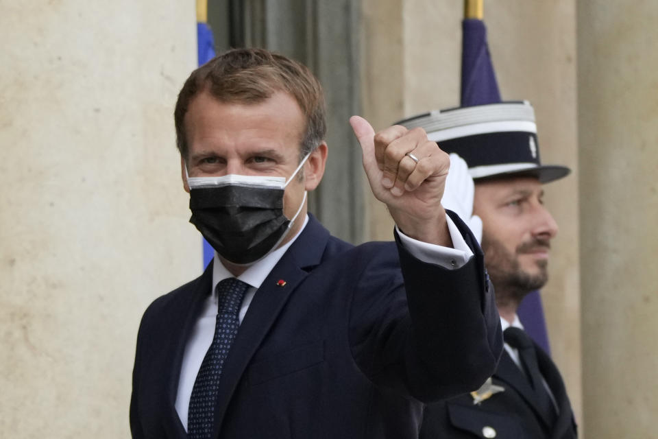 French President Emmanuel Macron thumbs up as he welcomes Prime Minister Kyriakos Mitsotakis Tuesday, Sept. 28, 2021 at the Elysee Palace in Paris. The leaders of Greece and France are expected to announce a major, multibillion-euro deal in Paris on Tuesday involving the acquisition by Greece of at least six French-built warships, Greek state ERT TV reported. (AP Photo/Francois Mori)