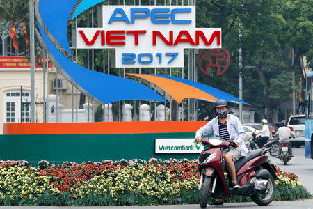 A motorbike waits in front of a sign promoting APEC Summit in Hanoi, Vietnam May 17, 2017. REUTERS/Kham