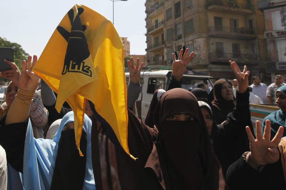 Supporters of Egypt's ousted President Mursi hold up banner of Rabaa sign during march in Shubra street in Cairo