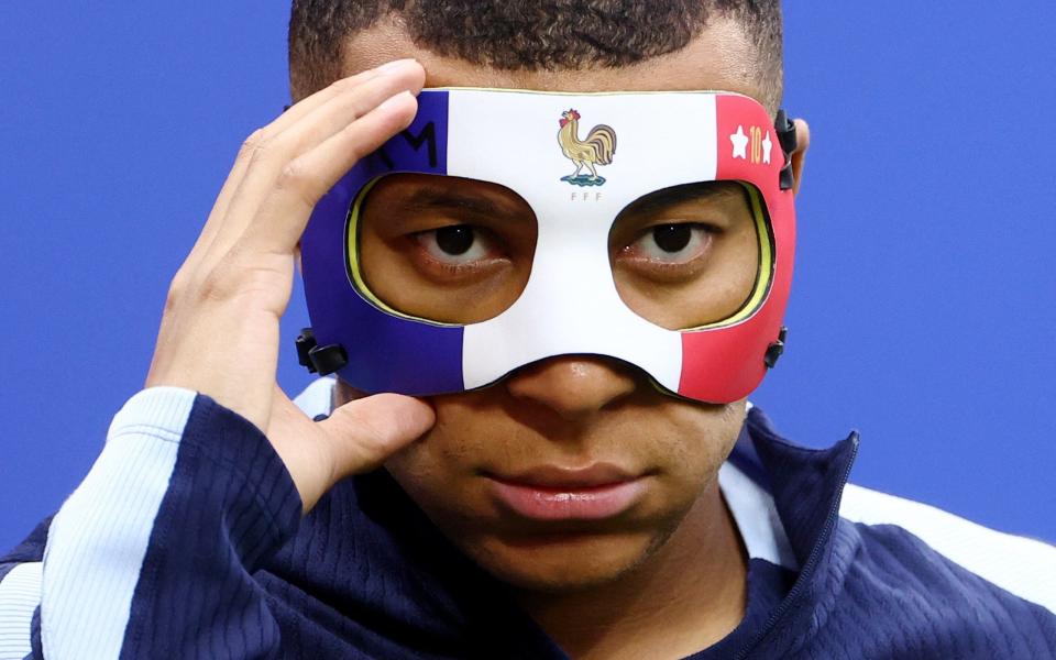 France's Kylian Mbappe wears a protective mask during training