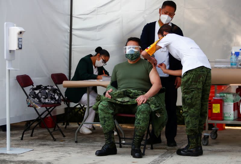 A military medical staff member receives a dose of the Pfizer/BioNtech COVID-19 vaccine at General Hospital, in Mexico City