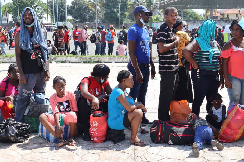 Migrants, mostly Haitians, queue outside a stadium to apply for humanitarian visas, in Tapachula