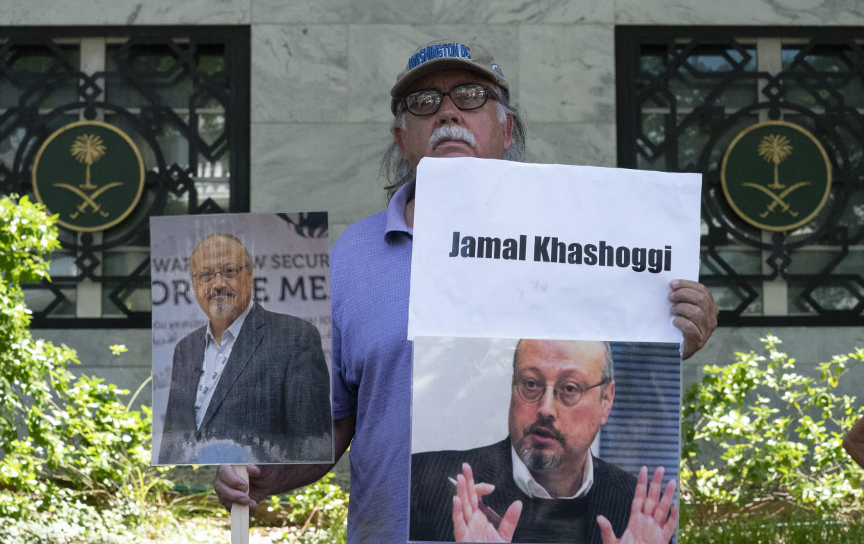 A man holding placards at the unveiling of Jamal Khashoggi Way.