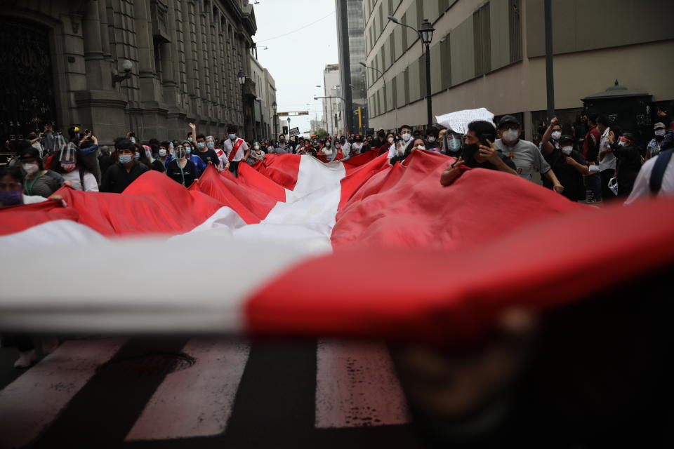 Supporters of former President Martin Vizcarra protest near Congress where lawmakers voted the previous night to remove Vizcarra from office in Lima, Peru, Tuesday, Nov. 10, 2020. Congress voted to oust Vizcarra over his handling of the new coronavirus pandemic and unproven allegations of corruption years ago. (AP Photo/Rodrigo Abd)