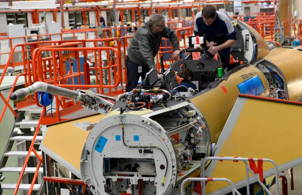 Employees of what was then Cassidian (now Airbus) assemble a Eurofighter plane for the Luftwaffe at the German production line in Manching, southern Germany, in 2013. <em>GUENTER SCHIFFMANN/AFP via Getty Images</em>