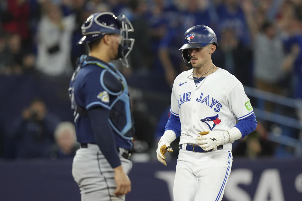 Toronto Blue Jays' Cavan Biggio crosses home plate in front of Tampa Bay Rays catcher Rene Pinto after hitting a two-run home run during the fourth inning of a baseball game Friday, Sept. 29, 2023, in Toronto. (Chris Young/The Canadian Press via AP)