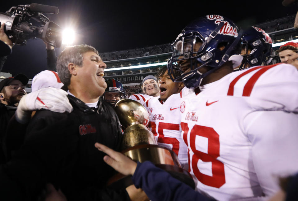 Mississippi coach Matt Luke, left, celebrates with players following their 31-28 win over Mississippi State in the Egg Bowl NCAA college football game in Starkville, Miss., Thursday, Nov. 23, 2017. (AP Photo/Rogelio V. Solis)