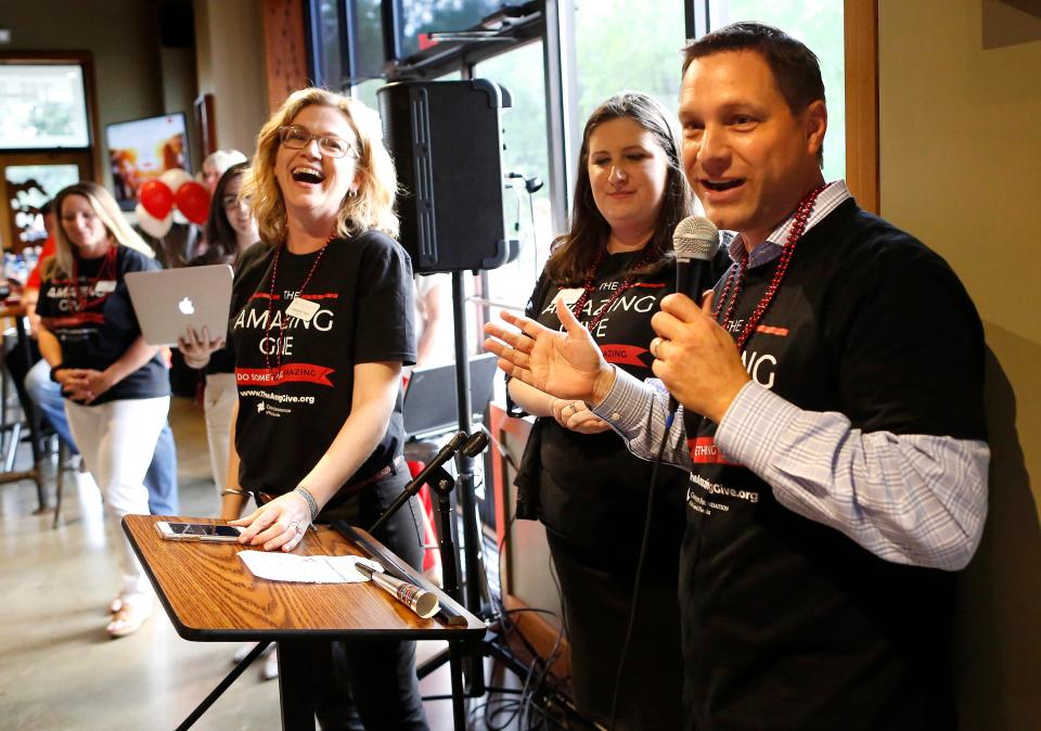 W.J. Rossi, right, board chair of the Community Foundation of North Central Florida, prepares to announce the donation total as Barzella Papa, left, president and CEO of the foundation, laughs during the wrap party for the Amazing Give, an annual one-day fund-raising event for nonprofit agencies in Alachua County, held at Swamp Head Brewery in 2017. The foundation last year awarded $4.18 million to organizations in the region.