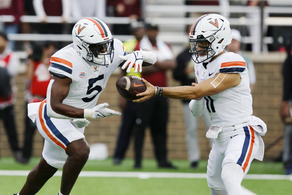 Virginia quarterback Tony Muskett (11) passes off to running back Kobe Pace (5) during the first half of an NCAA college football game against Boston College, Saturday, Sept. 30, 2023, in Boston. (AP Photo/Michael Dwyer)