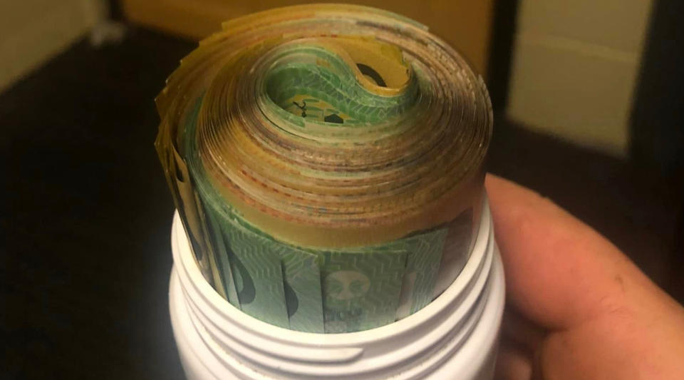 A roll of cash worth $7,000 rolled up in a medicine bottle. 