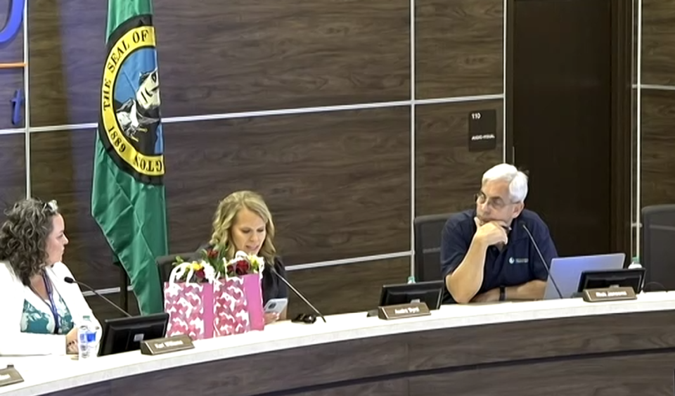 Richland School Board members Rick Jansons and Kari Williams watch as former board member Audra Byrd gives her final remarks before exiting the meeting. The Aug. 8 board meeting was her final as a school board member after voters approved an Aug. 1 recall measure to remove her and two other elected officials from office.